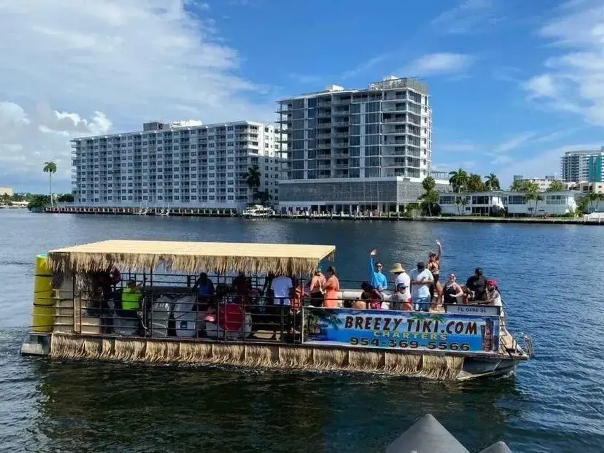 The Breezy Tiki — a 40-foot tiki pontoon boat with guests waving on the Fort Lauderdale Intracoastal
